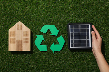 Recycling sign with solar panel on grass