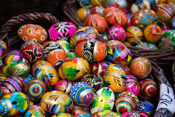 Fototapeta na wymiar Decorated Easter eggs on sale at the Easter fair bazaar stall, traditional market stand in Poland. Collection of colourful painted Paschal eggs. Wooden pisanki egg decorations.
