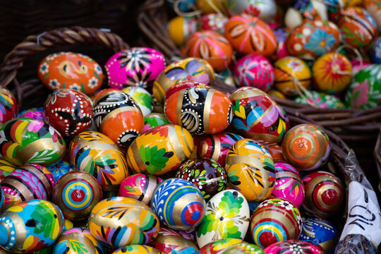 Decorated Easter eggs on sale at the Easter fair bazaar stall, traditional market stand in Poland. Collection of colourful painted Paschal eggs. Wooden pisanki egg decorations.