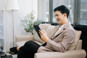 Asian woman sitting at a sofa using a laptop computer Navigating Finance and Marketing with...