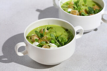 Chilled Summer Pea Soup with Croutons, Sour Cream, Mint, Pea Shoots, and Green Parsley Oil....