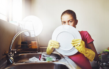 Portrait, washing dishes or kid with plate and gloves in kitchen sink in home for healthy hygiene....