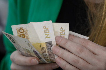 Obrót gotówkowy, kilka polskich banknotów w dłoni z bliska