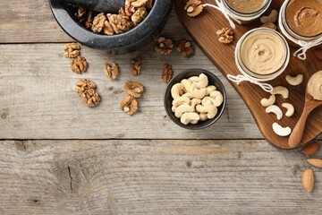 Making nut butters from different nuts. Fat lay composition with space for text on wooden table