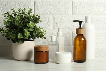 Fototapeta na wymiar Bath accessories. Personal care products on white table near brick wall