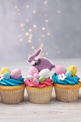 Tasty decorated Easter cupcakes on wooden table