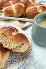 Hot cross buns and coffee on white marble table, closeup