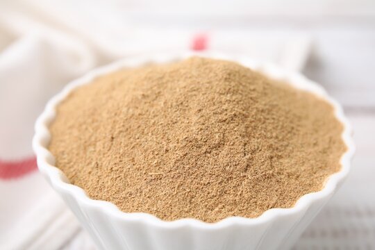 Dietary fiber. Psyllium husk powder in bowl on table, closeup