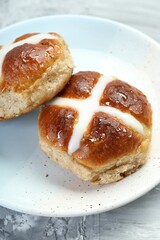 Tasty hot cross buns on gray textured table, closeup