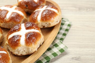 Tasty hot cross buns on wooden table, closeup. Space for text