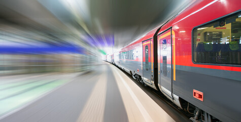 Red high speed train runs on rail tracks - The train is going too fast as a result the air pressure...