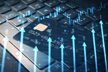 Close up of bank card on keyboard with growing blue vertical arrows and candlestick forex chart on...
