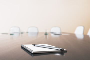 Close up of wooden boarding table with empty notepad and pen for morning notes. Blurry chairs in the backdrop. Business meeting concept. Mock up place, 3D Rendering.