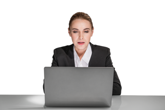 A professional woman in business attire working attentively on a laptop, against an isolated white background, depicting focus and concentration