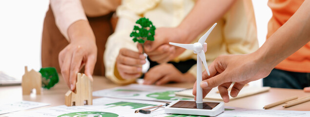 Windmill model represented using renewable energy placed during presenting green business on table...
