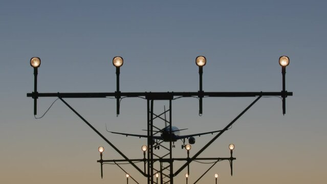 Airplane aligned with approach lighting system during early nightfall. Vertical tilt panorama