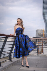 Beautiful young woman posing on the street wearing prom dress - 786030385