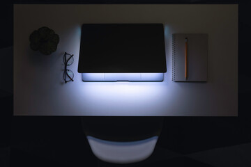 Laptop in the dark at night on the desktop.