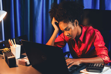 Exhausted and sleepy young African businesswoman taking a nap in her arm on desk at home office....