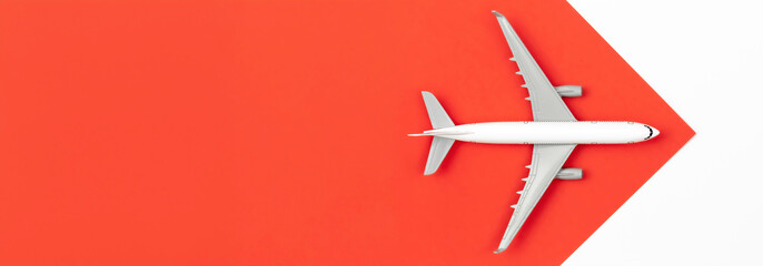 Airplane on a red and white background, flat lay, travel concept.