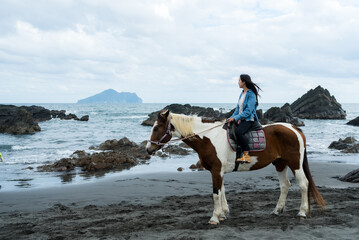 Tourist woman ride a horse beside the sea beach - 786046350