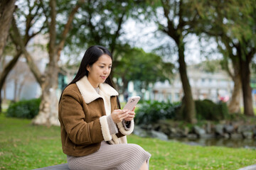 Woman use mobile phone at park - 786046742