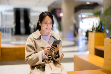 Woman use mobile phone in shopping mall - 786046785