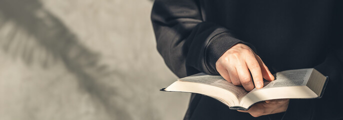 Close-up, holy Bible book in male hands.