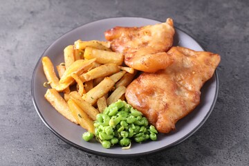Tasty fish, chips and peas on grey table