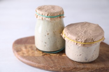 Sourdough starter in glass jars on light table, closeup
