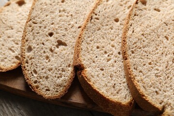 Freshly baked cut sourdough bread on wooden table, closeup