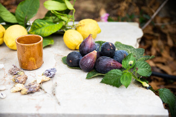 Several figs and lemons on a table in the forest