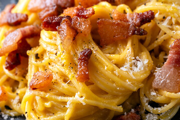Piatto di deliziosi e cremosi spaghetti alla carbonara, tradizionale ricetta di pasta condita con...