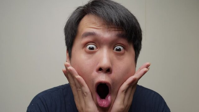 Young Chinese man astounded and shocked. Facial expressions and emotions