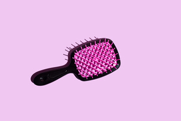 Vibrant Elegance top view of a hairbrush resting on a vibrant pink surface, adorned with a...