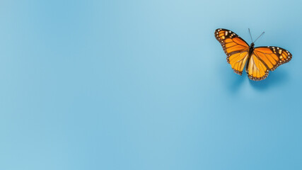 Fototapeta na wymiar An ethereal Monarch butterfly with intricate patterns lands on a serene blue backdrop, symbolizing hope and resilience