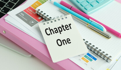 Notebook with text written CHAPTER ONE, concept of first time book writing, author start his novel,...