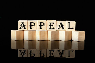 Word APPEAL on wooden cubes on a black background