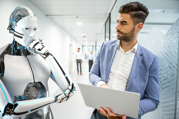Ein Angestellter und ein humanoider Roboter arbeiten zusammen an der Problemlösung