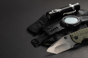 Everyday carry EDC items for men in black color - flashlight, watch and knife. Survival set. Minimal concept