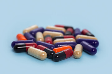 Heap of colorful medicine pills on blue background