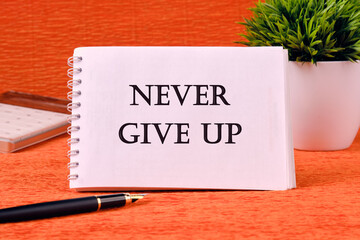 Never give up words on a white sheet of a notebook. Business concept