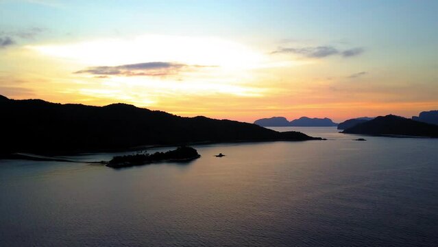 Aerial Panning Shot Of Silhouette Of Tranquil Mountains, Drone Flying Over Rippled Sea During Sunset - Palawan, Philippines