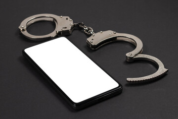 mobile phone with handcuffs, the concept of dependence on gadgets and digital technologies. Mockup