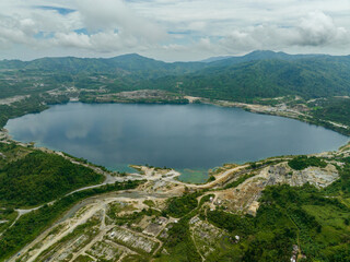 An artificial lake in an abandoned mining quarry. Quarry pond with turquoise water. Sipalay, Negros, Philippines.