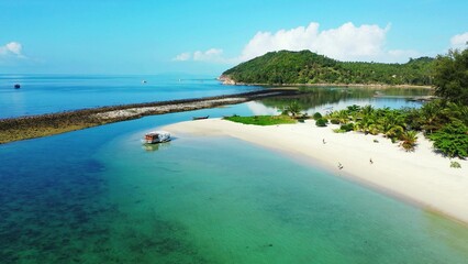 Scenic view of a blue tranquil seascape and a island with lush green nature on a sunny day