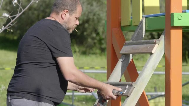 A carpenter's fine craftsmanship is on display as he builds a wooden playground