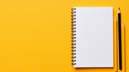 Pencils and Notebook on Yellow Background