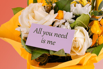 All you need is me. The phrase is written on a purple business card in a bouquet of flowers