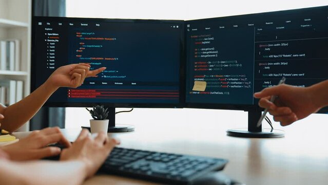 Slow motion back end software developer engineer for computer programming working together on debugging writing computing code, solving complex algorithms display on monitor in office. Burgeoning